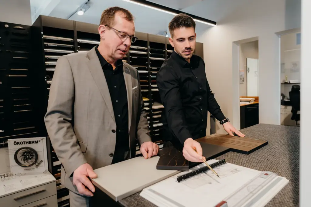 Jörg und Pascal Durczak arbeiten eine Küchenplanung mit Mustern aus
